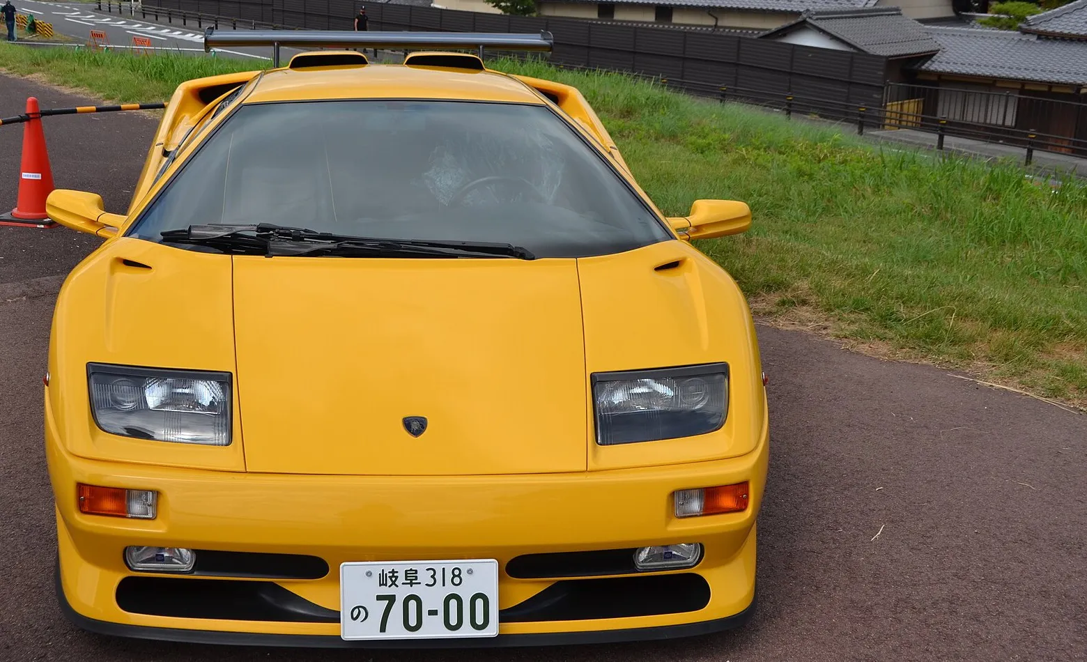 A yellow Lamborghini Diablo photographed head-on beside traffic cones on a tarmac slope